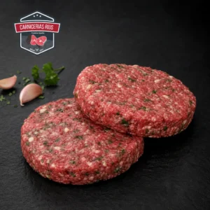 Hamburguesas crudas con ajo y perejil sobre pizarra.