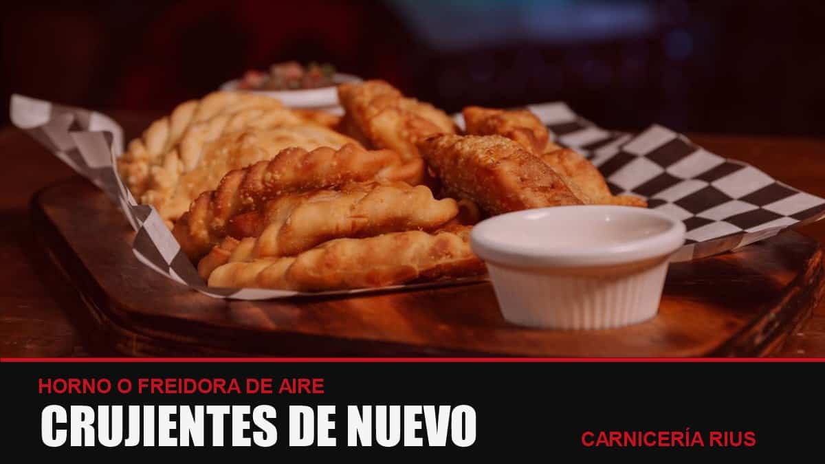 Empanadas caseras crujientes recalentadas en horno o freidora de aire sobre una bandeja de madera